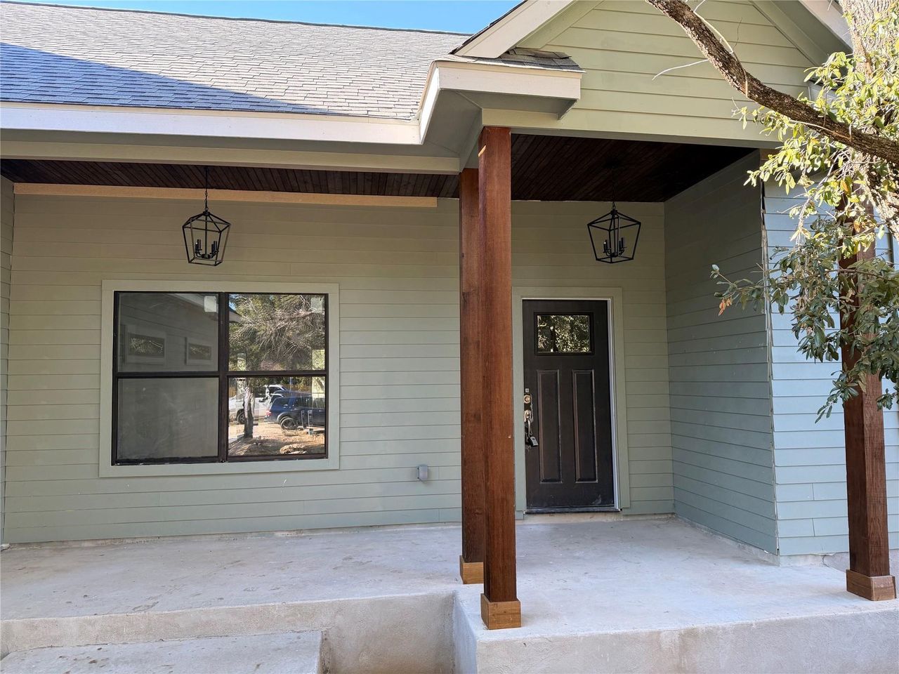 Doorway to property with a porch and roof with shingles Doorway to property with a porch and roof with shingles