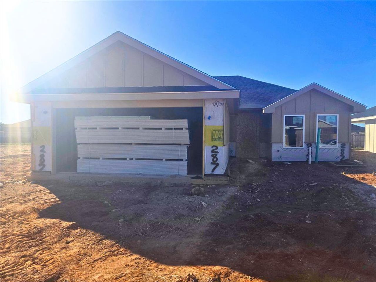 View of front of house with board and batten siding, a shingled roof, and driveway