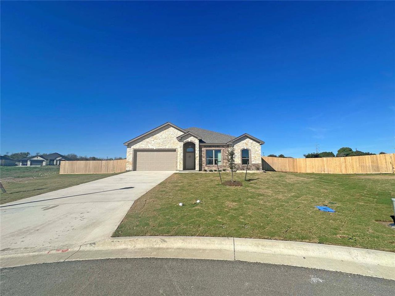 View of front of property with stone siding, concrete driveway, and a garage