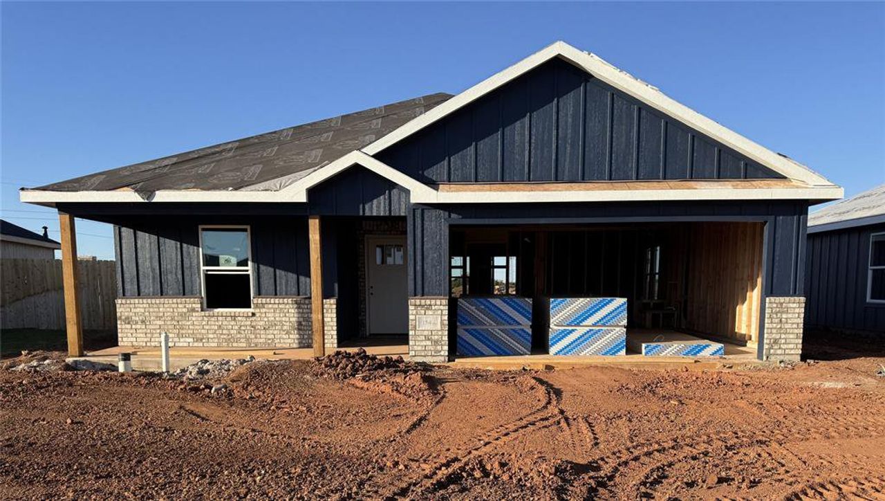 View of front of property with board and batten siding and brick siding