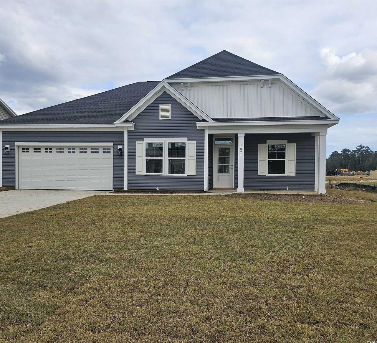 View of front of home featuring a front lawn, concrete driveway, a shingled roof, covered porch, and an attached garage View of front of home featuring a front lawn, concrete driveway, a shingled roof, covered porch, and an attached garage