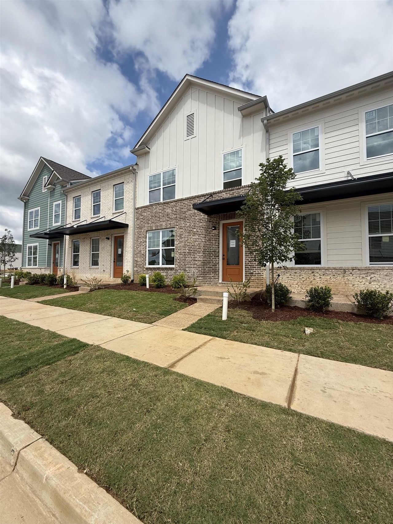 Contemporary townhome exterior featuring light brick and horizontal siding Contemporary townhome exterior featuring light brick and horizontal siding