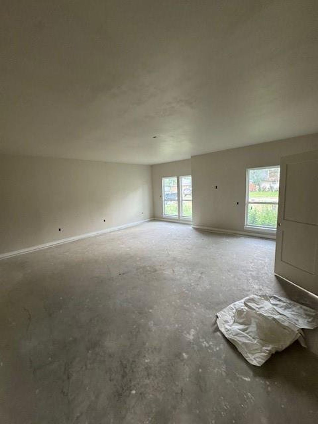 Unfurnished room with concrete flooring and baseboards Unfurnished room with concrete flooring and baseboards