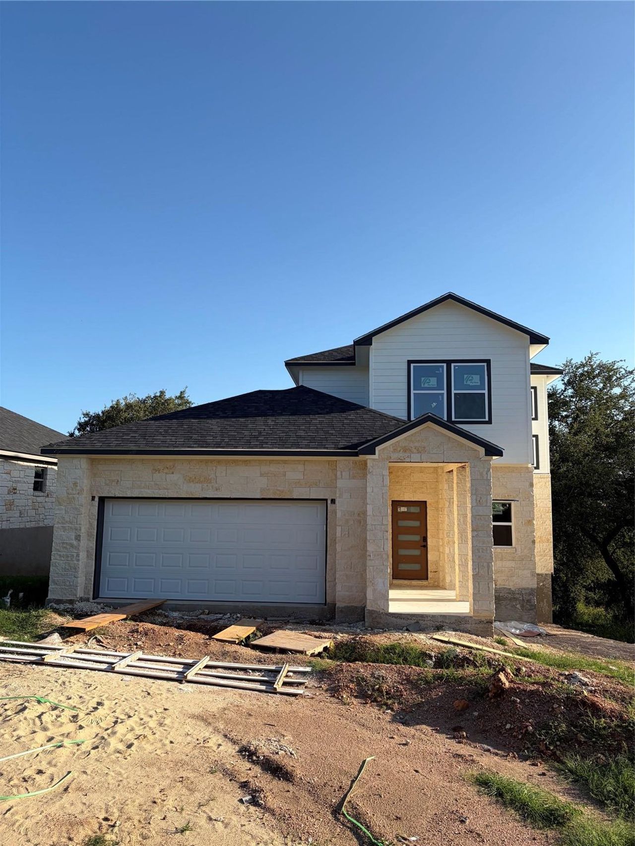A newly built two-story residence features a welcoming covered entry and an attached garage.