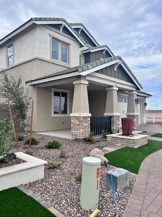 A modern two-story home with stone accents and tidy landscaping in Ridgeline at Acclaim by Fulton Homes (Avondale, AZ).