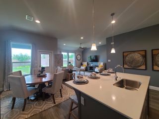 An open-concept living space featuring a sleek kitchen, cozy dining area, and inviting sitting room with modern decor.