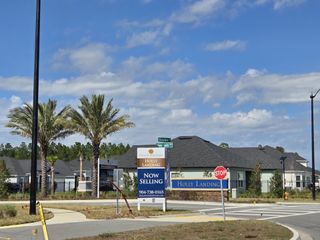 A welcoming community at Holly Landing at SilverLeaf by Dream Finders Homes, featuring palm trees and modern architecture (St. Augustine, FL).