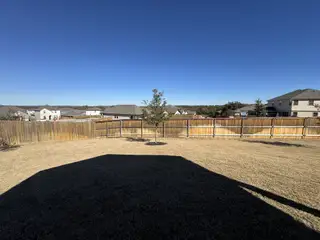 Street view Expansive fenced backyard with skyline view in Stonewall Ranch 40s by Taylor Morrison, Liberty Hill, TX.