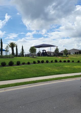 Community Amenities A beautifully landscaped park with playground equipment in Ridgeview by Trinity Family Builders (Clermont, FL).