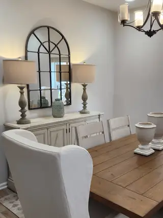 A cozy dining area featuring a rustic wood table, elegant upholstered chairs, and stylish decorative accents with soft lighting.