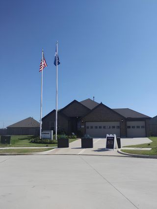 An elegant brick home with a three-car garage in Samara by Lennar (League City, TX), featuring stylish architecture and a grand entryway.
