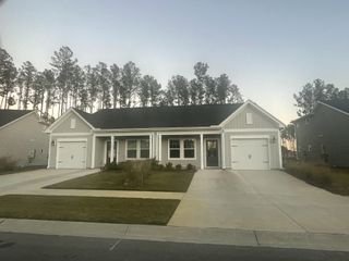 Charming gray home with white accents and neat lawns in Hammock Walk at Nexton by Ashton Woods (Summerville, SC).