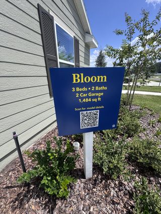 A charming home with dark shutters and a lush garden in Holstein Crossing: Holstein Crossing 50s by Lennar (Green Cove Springs, FL).