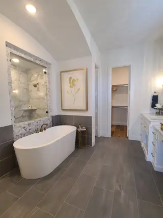 A luxurious bathroom featuring a freestanding tub, elegant fixtures, and paneled tiles for a modern aesthetic.