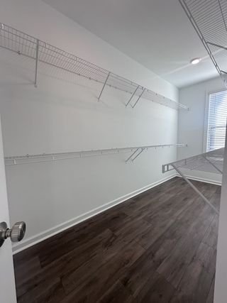 A spacious walk-in closet with sleek wooden floors and ample wire shelving for storage.