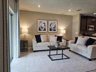 A cozy living room with plush beige sofas, abstract art, and soft lighting for a welcoming ambiance.