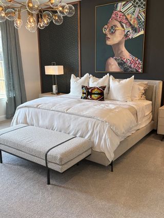 Model Home A chic bedroom featuring modern artwork, elegant lighting, and plush bedding for a stylish retreat.