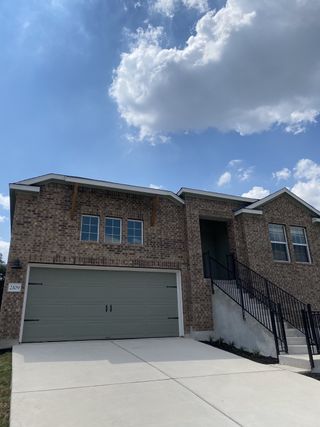 A charming brick home with a stylish front entry and spacious garage in Lively Ranch: Highlands Collection by Lennar (Georgetown, TX).