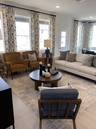 A cozy living room with modern furnishings, patterned curtains, and a sleek round coffee table.