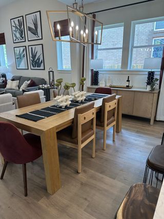 A cozy dining area with a wooden table, modern lighting, and stylish decor, featuring earthy tones and elegant wall art.