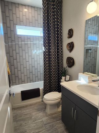 Model Home A chic bathroom featuring modern tiles, stylish cabinetry, and a bright ambiance.
