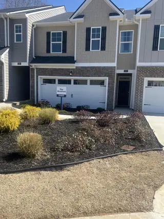 Charming townhouse with stylish facade and landscaped yard in Inverness at Sugarloaf by D.R. Horton (Lawrenceville, GA).