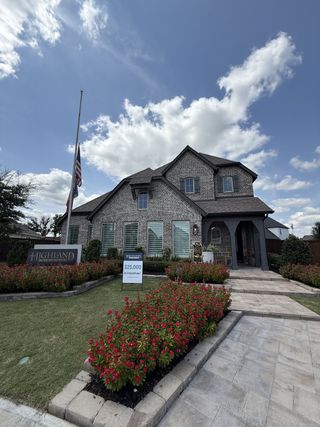 A beautiful brick home with lush landscaping and path in Meridiana: 50ft. lots by Highland Homes (Manvel, TX).