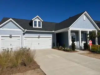 Street view Charming blue home with white trim and a three-car garage at Horizons at Summers Corner by Lennar (Ridgeville, SC).