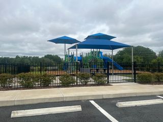 Community Amenities A modern playground with blue canopies and slides in Geneva Landings by Highland Homes of Florida (Davenport, FL).