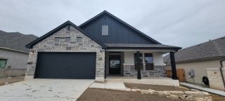 A modern stone facade home with a spacious garage in Ventana: 70's by Monticello Homes (Bulverde, TX).