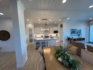 A modern, open-concept kitchen and living area with chic decor, featuring a spacious dining table and elegant lighting.