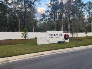 A welcoming entrance to Villages at Longbay by Lennar, featuring a stylish community sign and lush greenery in Middleburg, FL.