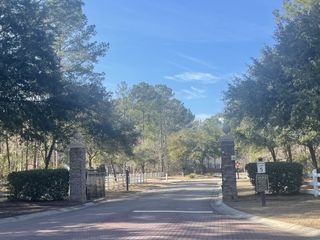 Street view A beautifully landscaped entrance with brick pillars in Carolina Bay by Center Park Homes (Ridgeville, SC).