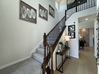 A beautifully designed staircase with a wooden railing and iron balusters, complemented by modern artwork on the walls.