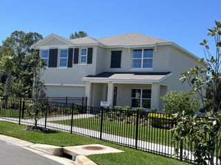 A stunning two-story home with elegant shutters and a fenced yard in the vibrant Berry Bay community by D.R. Horton (Wimauma, FL).