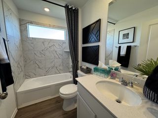 Model Home A sleek bathroom with marble wall tiles, elegant vanity, and contemporary decor. Perfect blend of style and functionality.