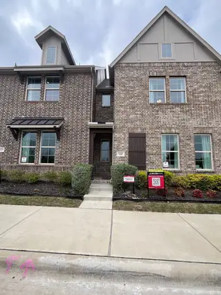 A modern brick townhouse with elegant details and a manicured lawn in Plano Gateway by Beazer Homes (Plano, TX).