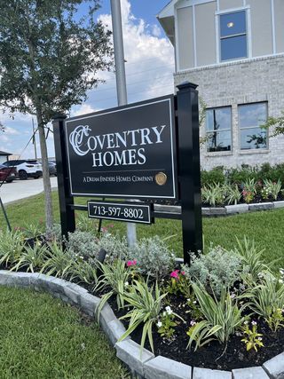 A beautiful landscaped entrance at Coventry Homes in Windcress, Cove, TX, featuring lush greenery and modern design.