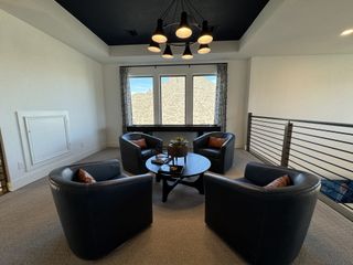A contemporary lounge area with sleek black chairs, a modern round table, and stylish lighting.