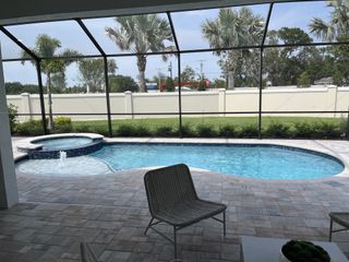 Model Home A serene pool area with a spa, paver patio, and lush greenery. Perfect for relaxation and entertaining.