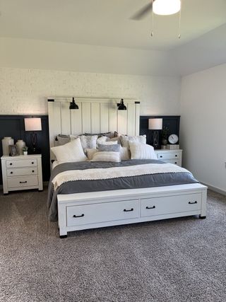 A cozy bedroom with a white brick accent wall, modern lamps, and plush carpeting. Perfect for restful slumber.