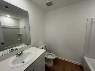 A modern bathroom featuring a white quartz countertop, chrome fixtures, and a bright ambiance.