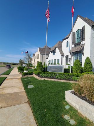 A charming white brick home with lush landscaping in Star Trail: 55ft. lots by Highland Homes, Prosper, TX.