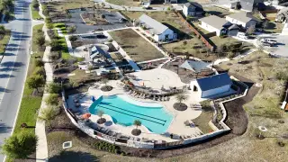 Aerial view of a vibrant community pool and play area in Homestead by CastleRock Communities (Schertz, TX).