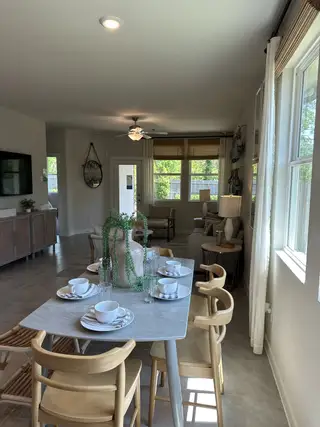 An inviting dining area with a sleek table, light wooden chairs, and soft natural lighting creating a warm atmosphere.