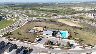 Community Amenities Aerial view of TRACE community with a pool and playground by Terrata Homes in San Marcos, TX.