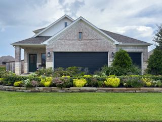 A beautiful brick home with manicured landscaping in Marvida by M/I Homes (Cypress, TX).