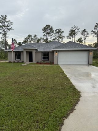 A charming single-story home with a manicured lawn in Marion Oaks by Perfect Deed Homes (Ocala, FL).