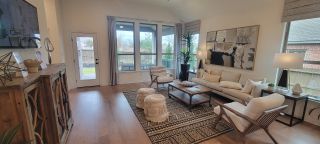 A cozy living room with high ceilings, large windows, and stylish decor, in a Davis Ranch home by Coventry Homes (San Antonio, TX), blending comfort and design.