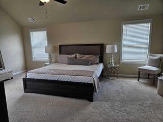 A cozy bedroom with neutral tones, featuring a plush bed, elegant side tables, and chic lamps, creating a serene retreat.